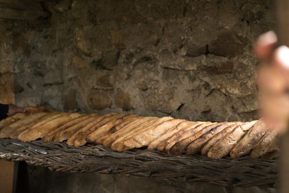 Freshly baked rustic bread loaves arranged against a textured stone background.